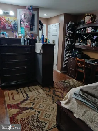 a bed sitting in a bedroom next to a cabinet with rug and a fireplace