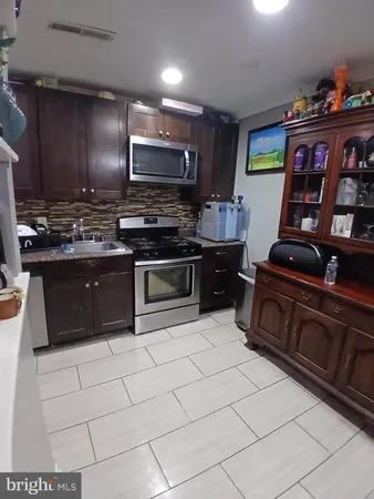 a kitchen with stainless steel appliances granite countertop a stove top oven a sink dishwasher and cabinets