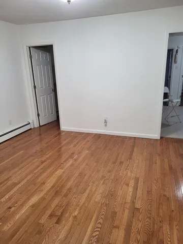 an empty room with wooden floor and closet