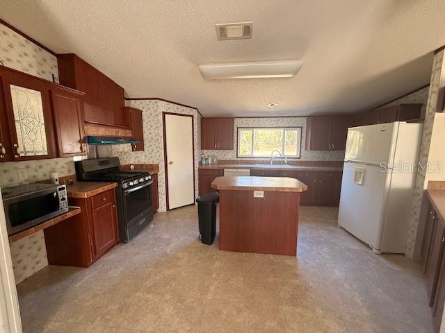 16636 Southwest 45th Street Ocala, FL 34481 - Photo 5 of 21 a kitchen with stainless steel appliances granite countertop a refrigerator stove and a sink