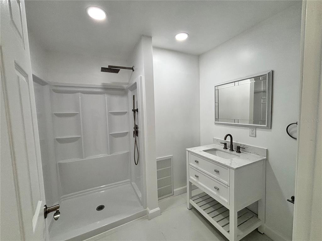 124 Coronado Road, Unit B DeBary, FL 32713 - Photo 12 of 18 a bathroom with a double vanity sink a mirror and a shower