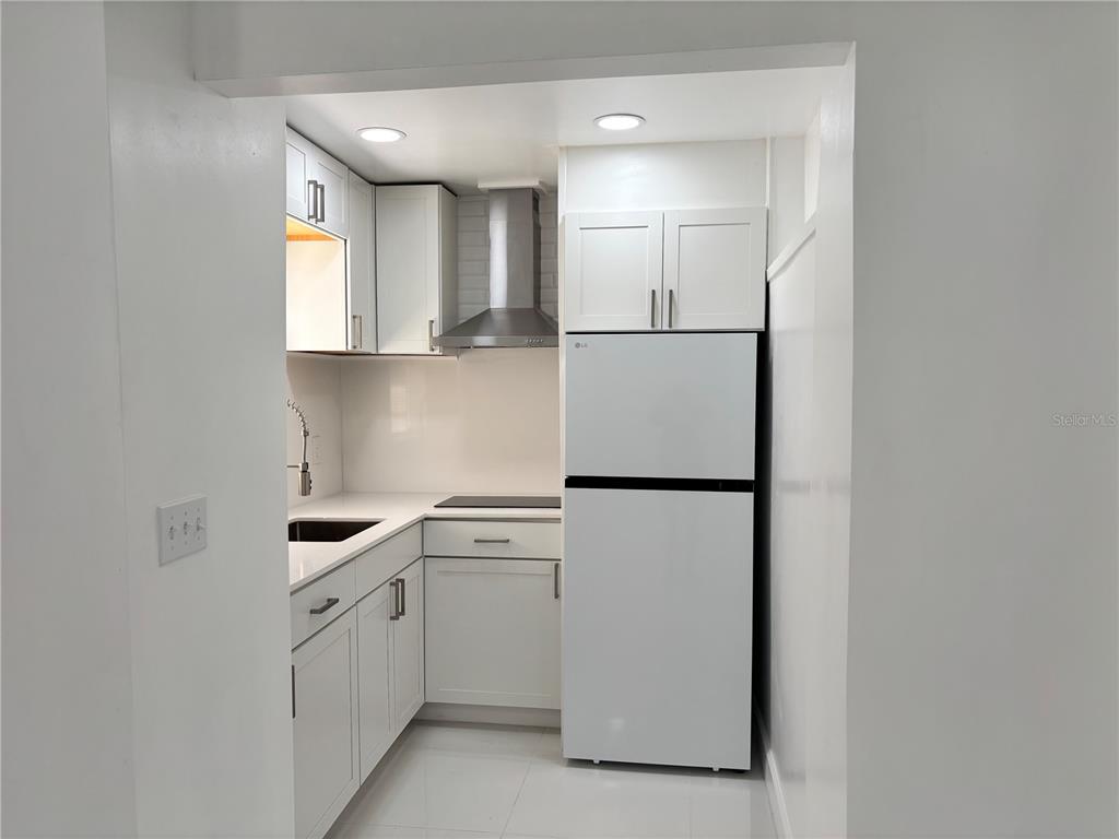 124 Coronado Road, Unit B DeBary, FL 32713 - Photo 3 of 18 a kitchen with white cabinets and white appliances