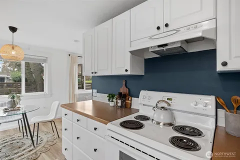 a kitchen with white cabinets and white appliances