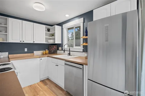 a kitchen with a sink cabinets stainless steel appliances and a window