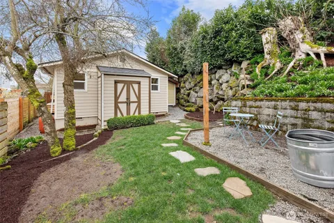 a view of a chair and table in backyard of the house