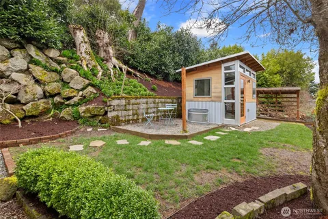 a view of a house with backyard and a tree