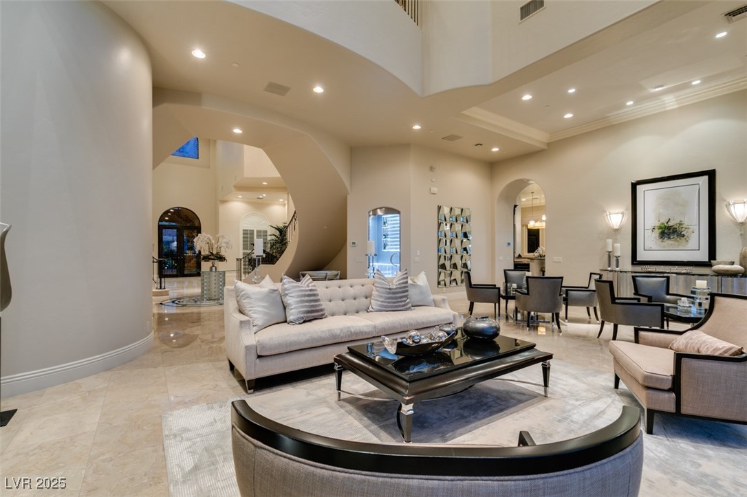 4 Awbrey Court Henderson, NV 89052 - Photo 13 of 72 Living area featuring a towering ceiling, arched walkways, and recessed lighting