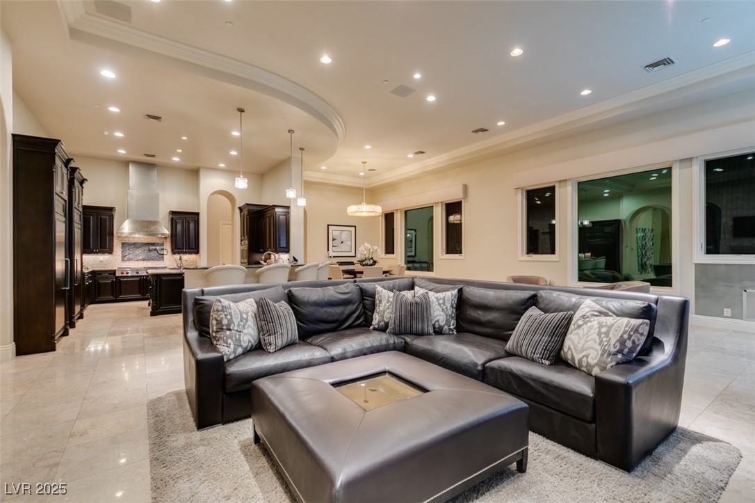 4 Awbrey Court Henderson, NV 89052 - Photo 24 of 72 Living area with arched walkways, recessed lighting, ornamental molding, a raised ceiling, and light tile patterned floors
