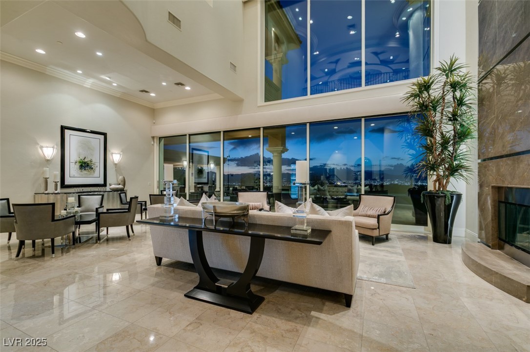 4 Awbrey Court Henderson, NV 89052 - Photo 3 of 72 Living area with recessed lighting, a towering ceiling, ornamental molding, a high end fireplace, and light marble finish floors