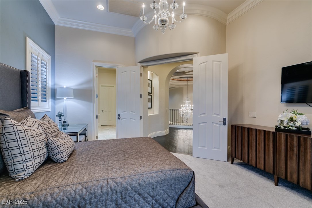 4 Awbrey Court Henderson, NV 89052 - Photo 46 of 72 Carpeted bedroom with a chandelier, crown molding, and arched walkways
