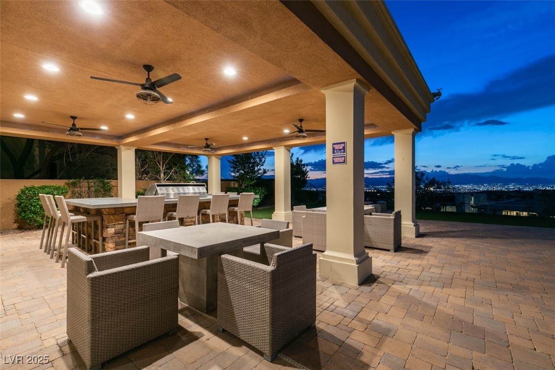 4 Awbrey Court Henderson, NV 89052 - Photo 54 of 72 Patio terrace at dusk featuring a patio, a mountain view, outdoor dining space, a ceiling fan, and outdoor lounge area