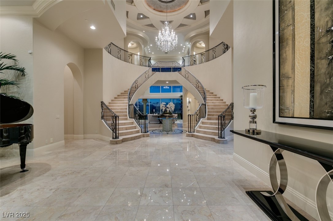 4 Awbrey Court Henderson, NV 89052 - Photo 8 of 72 Entrance foyer with stairs, coffered ceiling, a chandelier, marble tiled floors, and a high ceiling