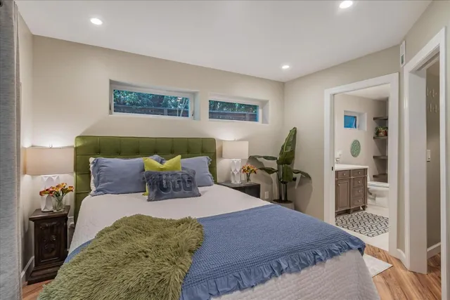 a large bedroom with a bed and wooden floor