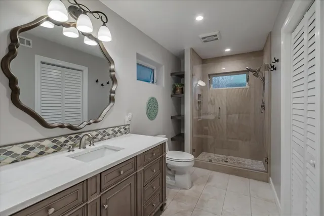 a bathroom with a sink a toilet and shower