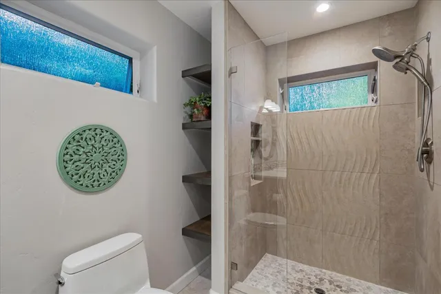 a bathroom with a toilet and a shower