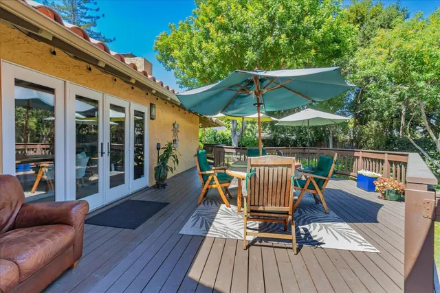 a view of deck with table and chairs under an umbrella with wooden floor