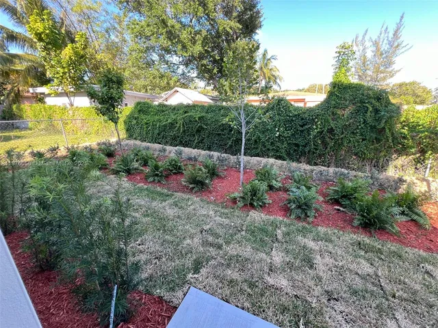 a view of a garden with large trees