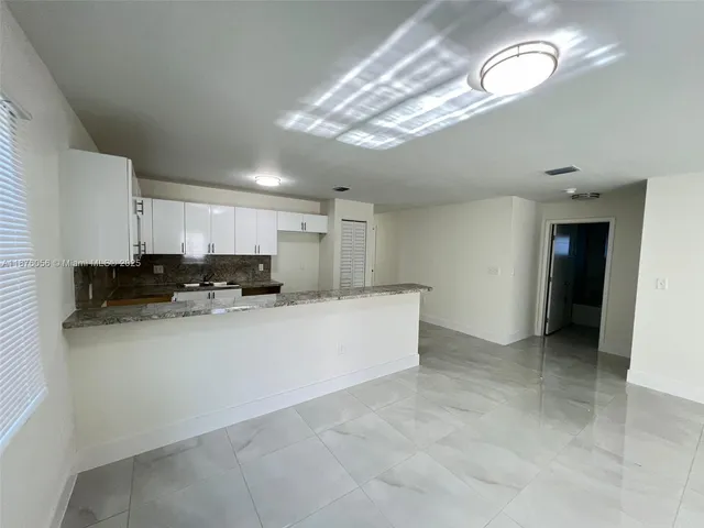 a large white kitchen with a large window