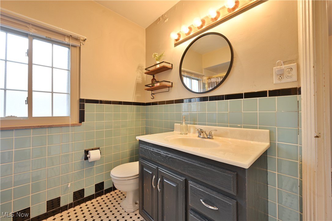 21887 Eaton Road Cleveland, OH 44126 - Photo 26 of 34 Bathroom with vanity, tile walls, a wainscoted wall, and tile patterned flooring