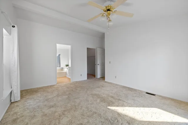 a backyard of a house with plants and trees with wooden fence