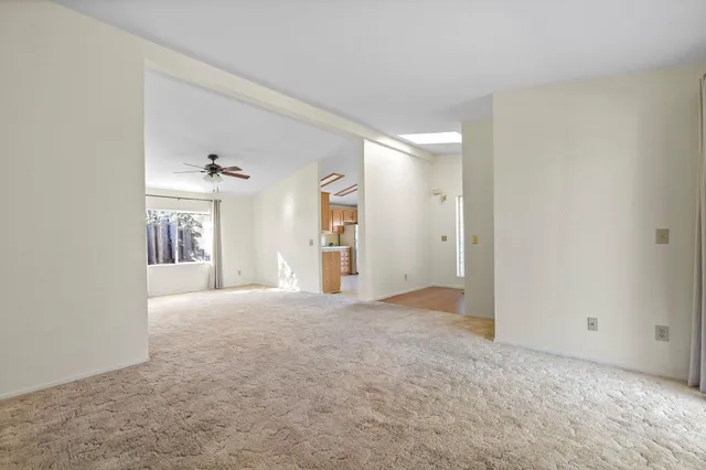 a view of a livingroom with a ceiling fan and window
