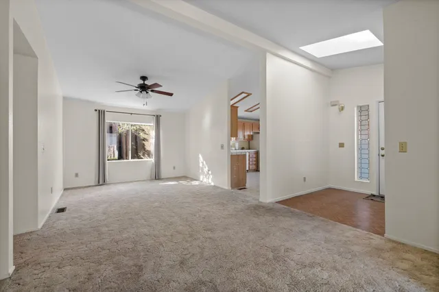 a view of a livingroom with a ceiling fan and window