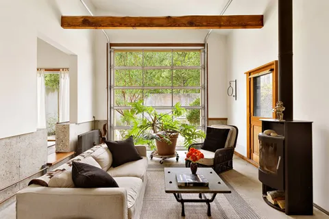 a backyard of a house with table and chairs with wooden fence and plants