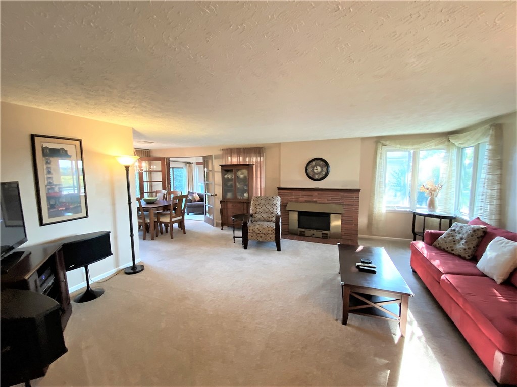 1560 Westfall Road Brighton, NY 14618 - Photo 8 of 40 Step inside the main living room with a cozy firep