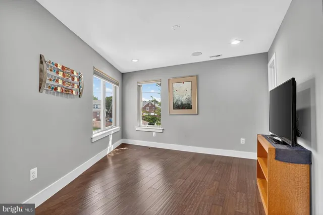 a living room with hard wood floors and a flat screen tv