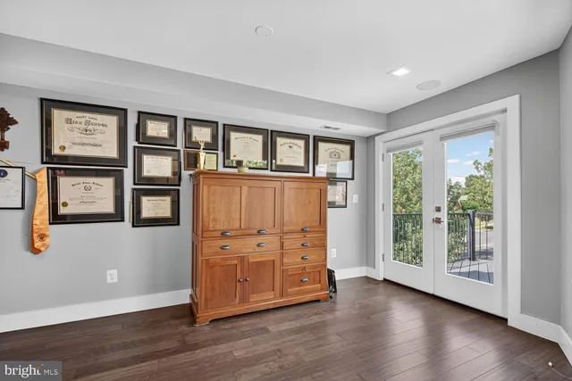 a living room with wooden floor and a book shelf