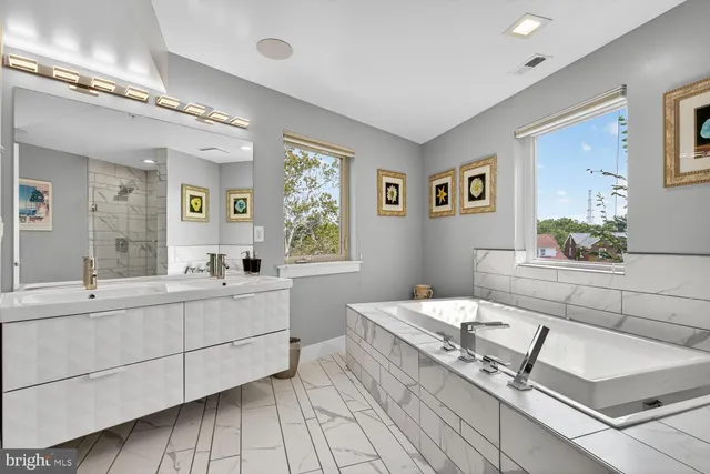 a bathroom with a sink mirror and shower