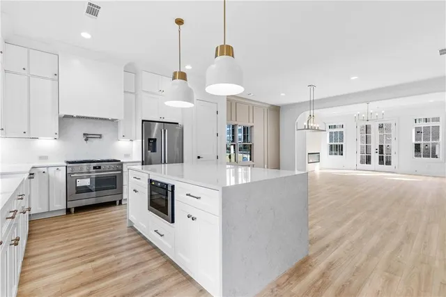 a kitchen with stainless steel appliances granite countertop a stove and cabinets