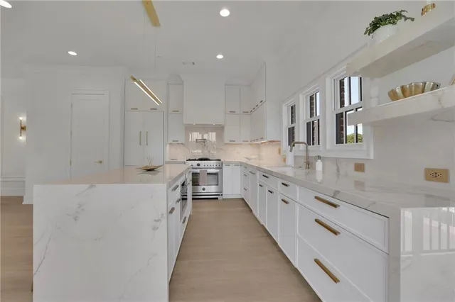 a large kitchen with stainless steel appliances lots of counter space and wooden floor