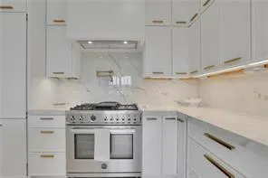 a stove top oven sitting inside of a kitchen