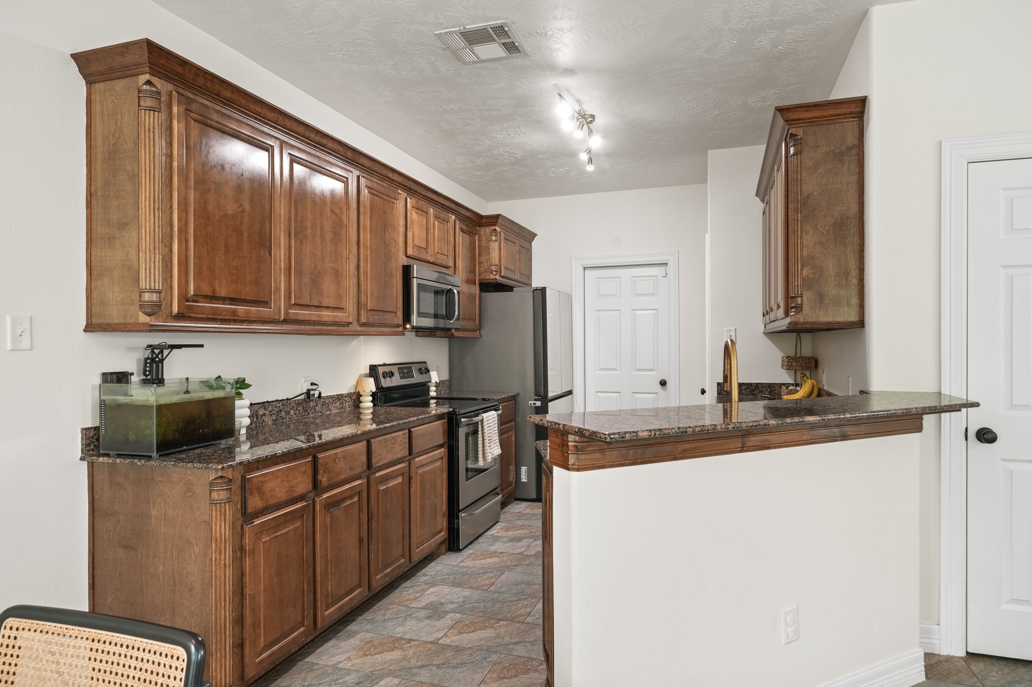 6101 Fox Ridge Drive Angleton, TX 77515 - Photo 14 of 30 a kitchen with stainless steel appliances granite countertop a sink stove cabinets and refrigerator