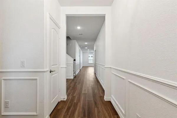 a view of a hallway with wooden floor and staircase