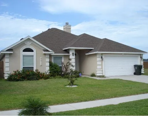 a front view of a house with a garden and yard