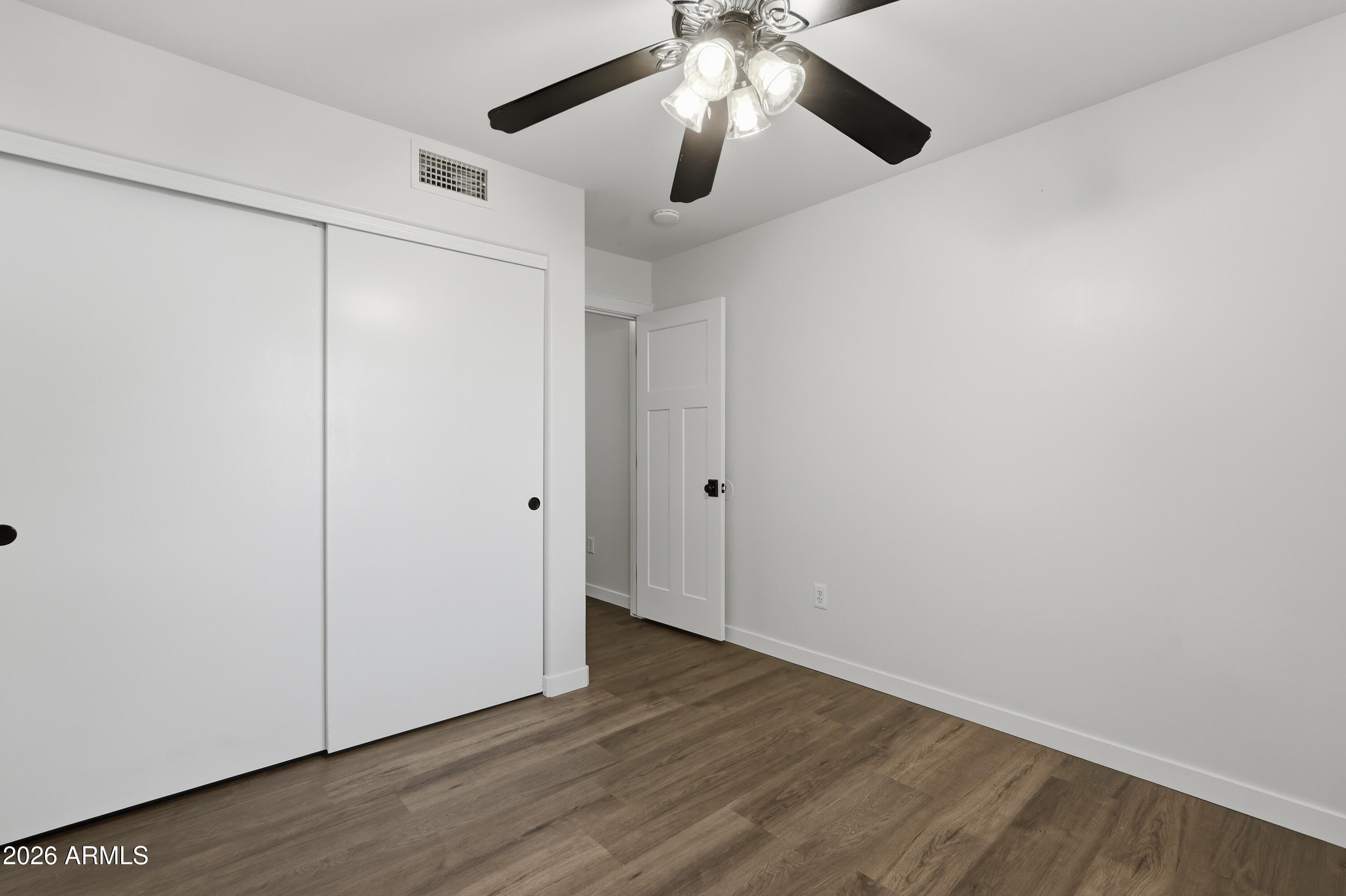 2497 East Ivanhoe Court Gilbert, AZ 85295 - Photo 15 of 57 an empty room with wooden floor chandelier fan and closet area