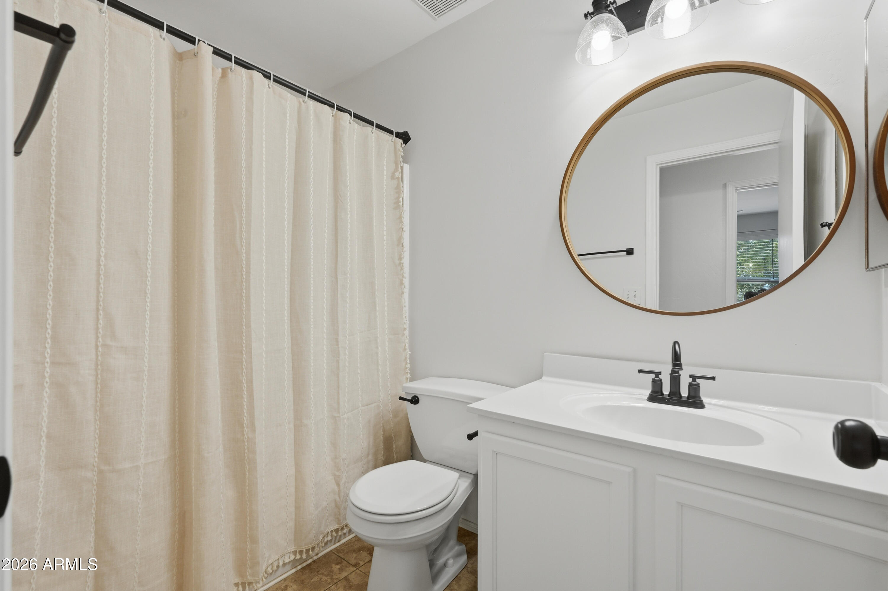 2497 East Ivanhoe Court Gilbert, AZ 85295 - Photo 34 of 57 a bathroom with a sink a mirror a toilet and a window