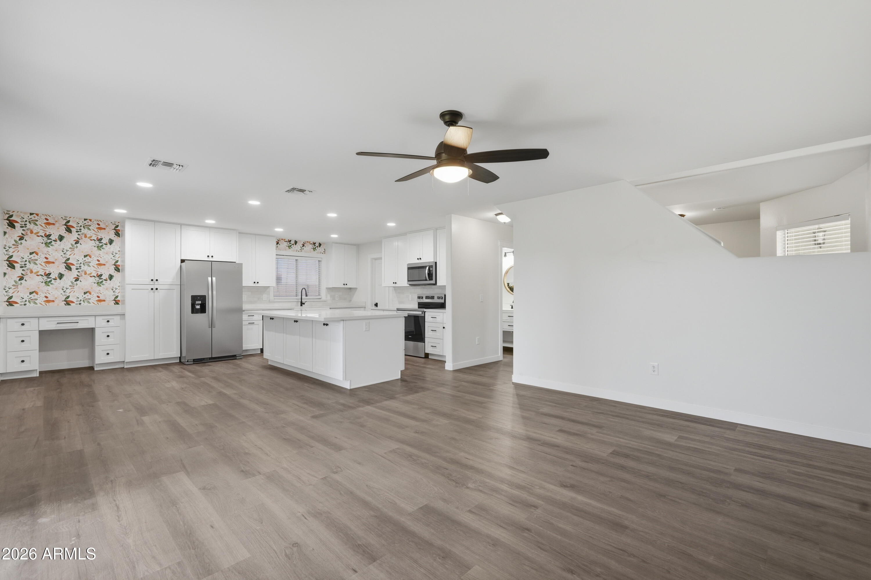 2497 East Ivanhoe Court Gilbert, AZ 85295 - Photo 7 of 57 a view of a kitchen with a sink dishwasher a refrigerator with white cabinets and wooden floor