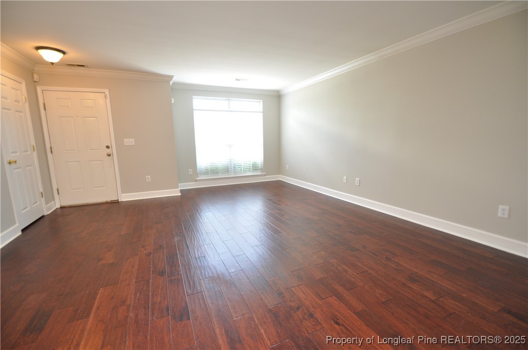 8600 Neuse Landing Lane, Unit 101 Raleigh, NC 27616 - Photo 6 of 29 a view of an empty room with wooden floor and a window