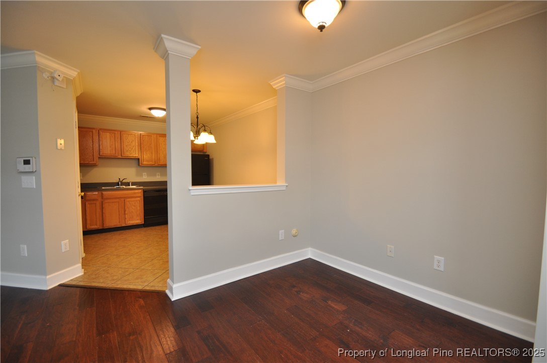 8600 Neuse Landing Lane, Unit 101 Raleigh, NC 27616 - Photo 7 of 29 an empty room with wooden floor kitchen view and a window