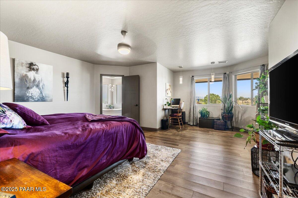 1617 Windmill Way Chino Valley, AZ 86323 - Photo 19 of 42 a spacious bedroom with a bed and a flat screen tv