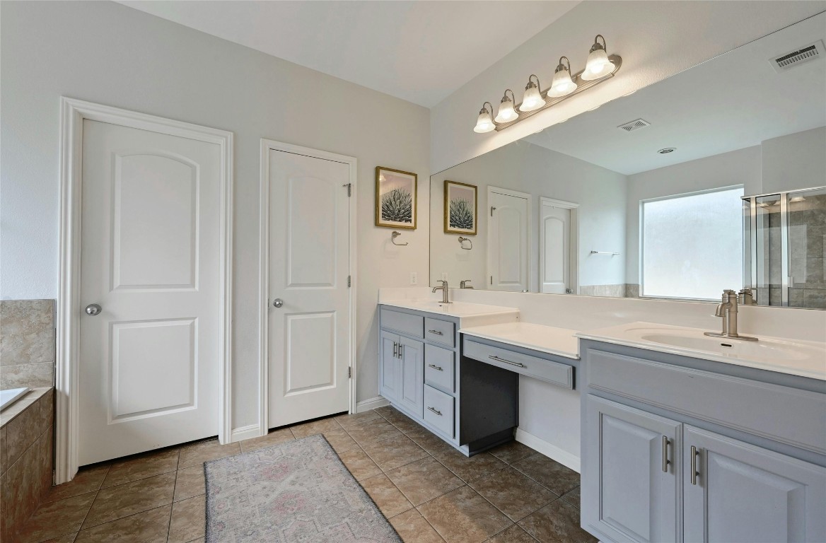 130 Farm House Road San Marcos, TX 78666 - Photo 18 of 35 a spacious bathroom with a double vanity sink double and mirror