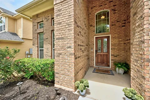 a view of a brick house with potted plants