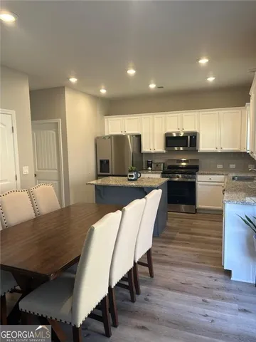 a view of kitchen with cabinets table and chairs