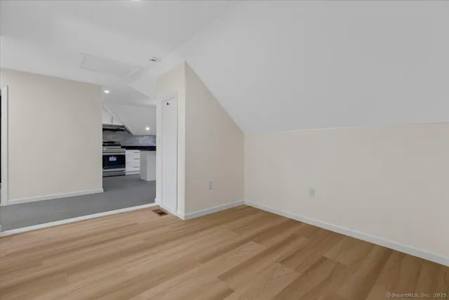a view of a kitchen with wooden floor and a refrigerator