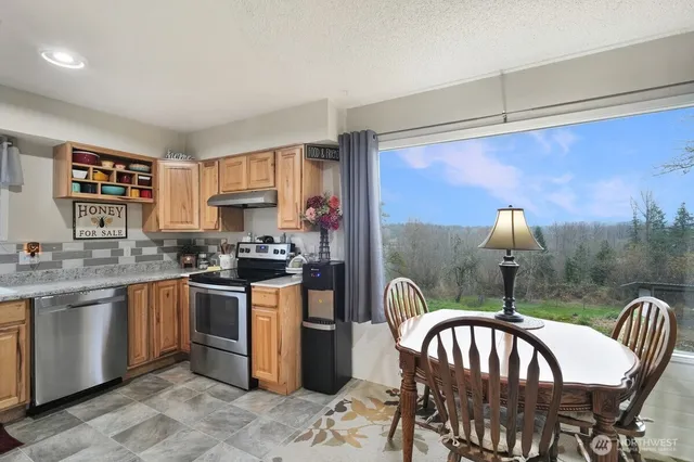 a kitchen with stainless steel appliances granite countertop a sink and a refrigerator