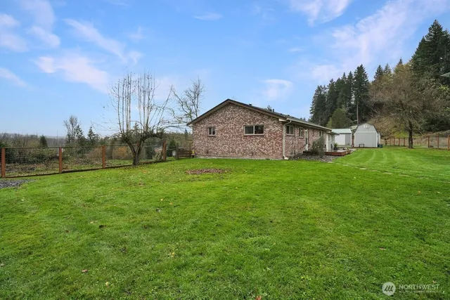 a view of a house with backyard and trees
