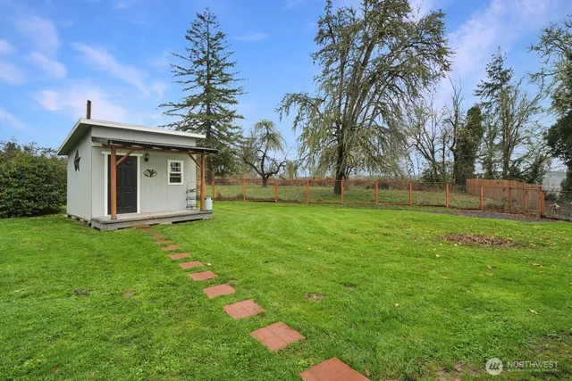 a view of a house with backyard and trees